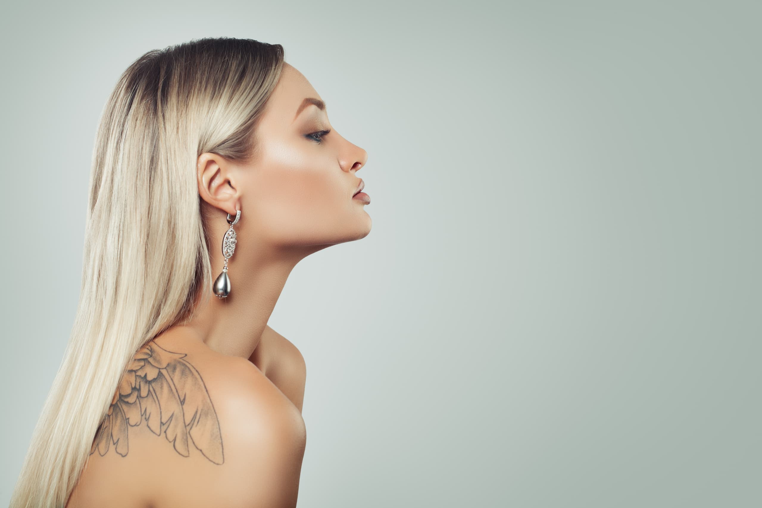 Tetování na rameni – profil ženy s tetováním křídel